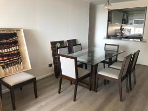 パプドにあるPrecioso departamento Papudo a pasos de la playaのダイニングルーム(ガラスのテーブル、椅子付) +11枚の写真