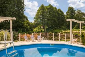a swimming pool with two chairs and a gazebo at Grabowa 19 in Brzozówka