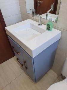 APARTAMENTO ENCANTADOR, À 400 METROS DA PRAIA DE PALMAS, في جوفيرنادور سيلسو راموس: حمام مع حوض أبيض ومرآة