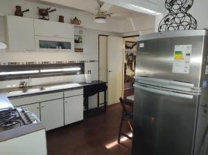 una cucina con armadi bianchi e frigorifero in acciaio inossidabile di La Nenena a Rosario