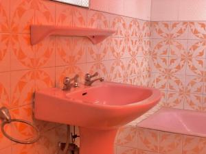 y baño con lavabo rosa y aseo. en GRACE LODGE ONITSHA, en Onitsha