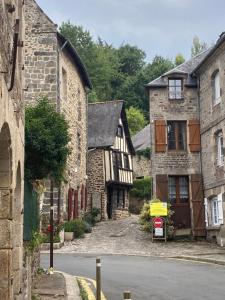 un groupe de bâtiments en pierre sur le côté d'une rue dans l'établissement L'Aparthé Dinan - Vue sur la place du marché, à Dinan
