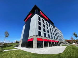 a large building with a red stripe on it at Grand Hotel TiMES Blainville-Mirabel in Blainville