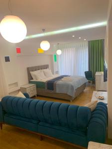 um quarto com uma cama e um sofá azul em AE Apart Hotel em Sarajevo