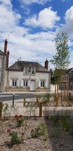 una gran casa blanca al lado de una calle en Les chambres de Saint-Benoit, en Saint-Benoît-sur-Loire