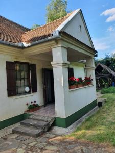 una pequeña casa blanca con flores en una ventana en Molnar Vendeghaz - Hajdúszoboszló Keleti-Főcsatorna, en Hajdúszoboszló