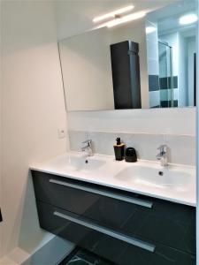 Appartement moderne entièrement rénové في أوريلاك: حمام مع حوض ومرآة