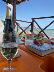 a table with a glass of wine and a book at Bukhta in Vapnyarka