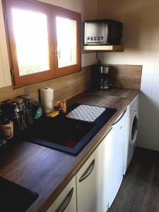 a kitchen with a counter top with a microwave at Chalet en bois "Le Libellule" in Sigean