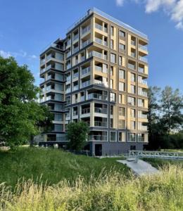 een hoog appartementencomplex op een heuvel naast een veld bij Apartamenty Złota 15-Kadzielnia View in Kielce