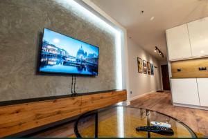 a living room with a flat screen tv on a wall at Apartamenty Złota 15-Kadzielnia View in Kielce