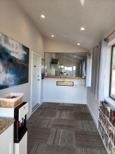 a hallway with white walls and a large mirror at Relax Inn in Hendersonville