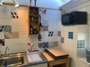 a kitchen with a sink and some tiles on the wall at Vintage Apartment Hase 