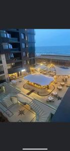 a large building with a pool and tables and umbrellas at SOLMAR Studio Sea View in Năvodari