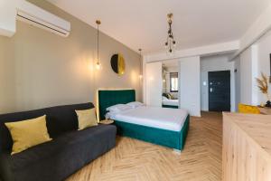 a bedroom with a bed and a couch at SOLMAR Studio Sea View in Năvodari