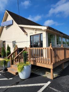 a house with a wooden deck in a parking lot at Relax Inn in Hendersonville