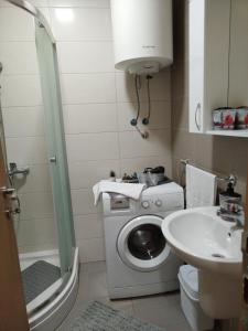 een badkamer met een wasmachine en een wastafel bij APARTMAN-STUDIO TEA SU in Subotica