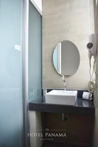 a bathroom with a sink and a mirror on a counter at HOTEL BOUTIQUE PANAMÁ in Guayaquil