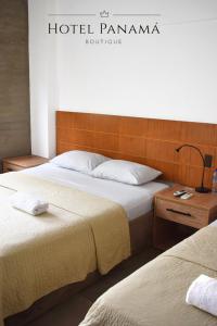 2 camas en una habitación de hotel con un cartel en la pared en HOTEL BOUTIQUE PANAMÁ, en Guayaquil
