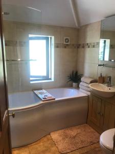 a bathroom with a bath tub and a sink at 3 bedroom home with stunning views and hot tub in Birmingham