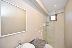 a bathroom with a sink and a glass shower at Apartments Langust in Sveti Stefan