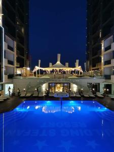a large swimming pool in front of a building at night at SOLMAR Studio Sea View in Năvodari