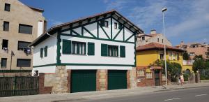 a white and green house with a green garage at Casa Vasca in Llanes