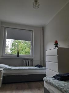 a bedroom with two beds and a window at Apartament Tade in Sopot