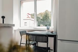 una mesa y sillas en una cocina con ventana en Rīgas ielas apartamenti 1, en Valmiera
