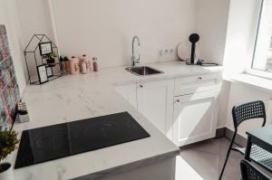 cocina blanca con fregadero y encimera en Rīgas ielas apartamenti 1, en Valmiera