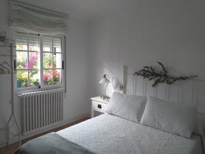 Habitación blanca con cama y ventana en Casa Jardín, en Monforte de Lemos