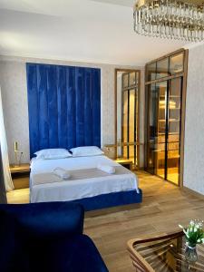 a bedroom with a large bed with a blue wall at Tbili Metekhi Boutique Hotel in Tbilisi City