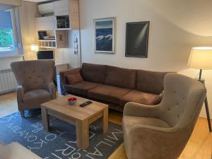 a living room with a couch and two chairs and a table at Apartman Uma in Sarajevo