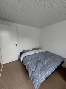 a bedroom with a bed in a white room at Stuelejlighed med have og overdækket terrasse in Odense