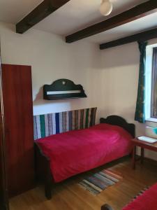 1 dormitorio con 1 cama roja en una habitación en Molnar Vendeghaz - Hajdúszoboszló Keleti-Főcsatorna, en Hajdúszoboszló