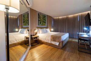 Cette chambre comprend deux lits et un bureau. dans l'établissement Hotel Cassino Tower São José do Rio Preto by Nacional Inn, à Sao Jose do Rio Preto