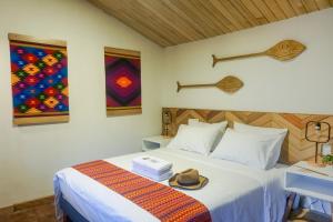 a bedroom with a bed with a hat on it at Pacha Eco Lodge Glamping & Hotel in Archidona