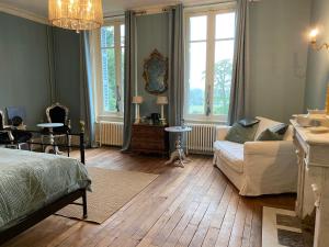 uma sala de estar com uma cama e um sofá em Chateau du Grand Lucay em Bourbon-lʼArchambault