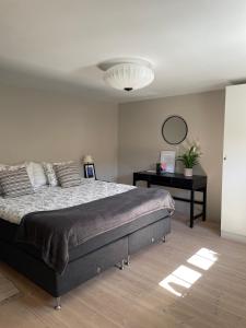 a bedroom with a bed and a desk with a mirror at Ingridgården in Båstad