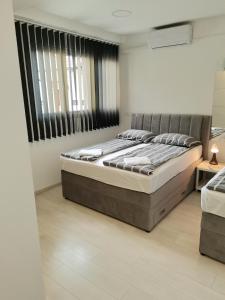 a bedroom with a bed and a large window at Apartments Petrova170 in Zagreb