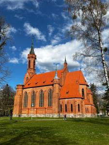 una gran iglesia de ladrillo con techo naranja en Salt Garden Apartments, en Druskininkai
