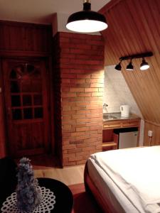 a bedroom with a bed and a brick wall at Willa Kasprusie in Zakopane
