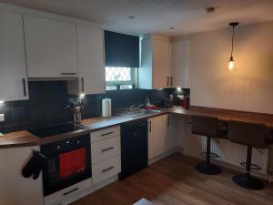 uma cozinha com armários brancos e um forno com placa de fogão em Cosy Central Canterbury - Modern Victorian em Kent
