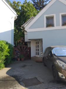 un coche aparcado frente a una casa blanca en Galeria Villa, en Veszprém