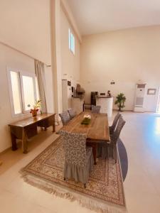 a living room with a wooden table and chairs at SHAIKHA villa in Umm al ‘Amad