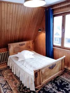 a bedroom with a bed with a wooden wall at Willa Kasprusie in Zakopane