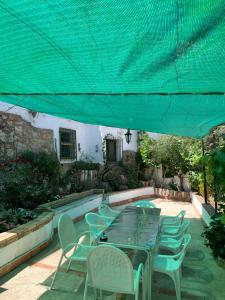 una mesa y sillas bajo una sombrilla verde en Apartamento Rural Cardera en la Sierra de Cazorla, en Beas de Segura