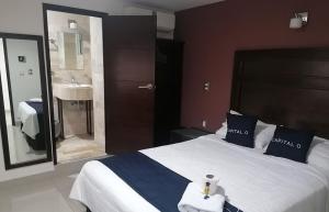 a bedroom with a large bed and a bathroom at Hotel Granda Inn in Tuxtla Gutiérrez