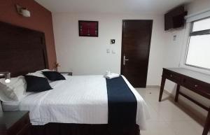 a bedroom with a bed and a dresser and a window at Hotel Granda Inn in Tuxtla Gutiérrez