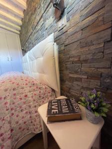 a bedroom with a bed and a table with a book at IL CAPPELLAIO MATTO in Livorno